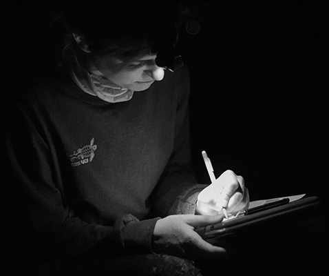 Student taking notes in the dark