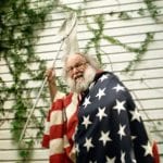 Stuart M. Fullerton with American flag draped around him