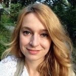 Gesca Borchardt A woman with blonde hair smiling at the camera in a natural setting.
