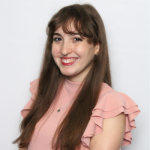 Cynthia Castro A woman with long brown hair smiling at the camera, wearing a pink ruffled top.