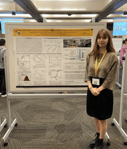 A person stands next to a large scientific poster titled “Cloud condensation nuclei activity of fresh and aged submicrometer maleic acid aerosol particles" at an academic conference.