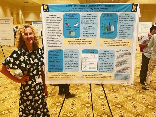 A woman standing in front of a poster at a conference.