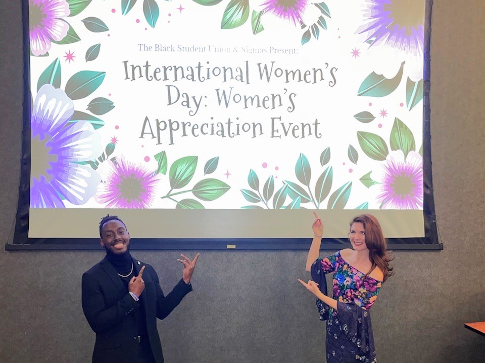 Two individuals presenting at an international women's day: women's appreciation event.