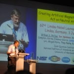 A man presenting at a conference with a slide titled "creating artificial images: art in the natural world" projected behind him.