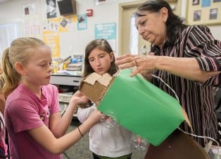 Alyssa Dorrien, left, and Kady Turner, along with teacher Taru Joshi, create a model for a recycling truck to be manufactured from all recycled material for Project SavEarth. Ed Ruping/ The Chronicle