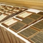 Rows of assorted framed certificates displayed on a table.