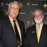 Two senior men in suits posing together at a UCF statistics alumni event.