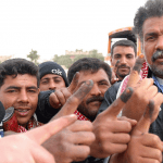 A group of middle eastern men gesturing with their thumbs up to the camera, expressing enthusiasm or approval.