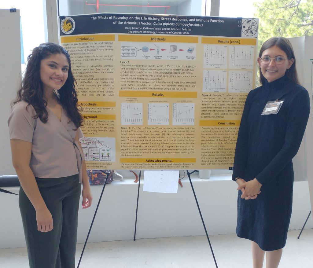 Holly Monroe and Kathleen Velez standing next to their research poster