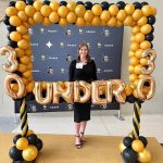 Alanna Reynolds standing behind gold balloons