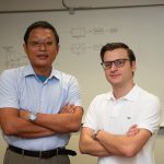 Associate Professor Hsin-Hsiung “Bill” Huang and student Hayden Hampton standing in front of whiteboard