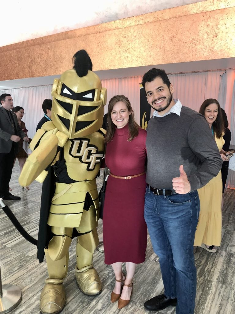 Alanna Reynolds standing with Knightro and husband Darren Reynolds