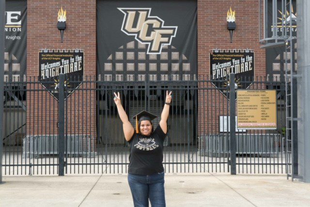 Alexis Weber standing in front of a UCF banner