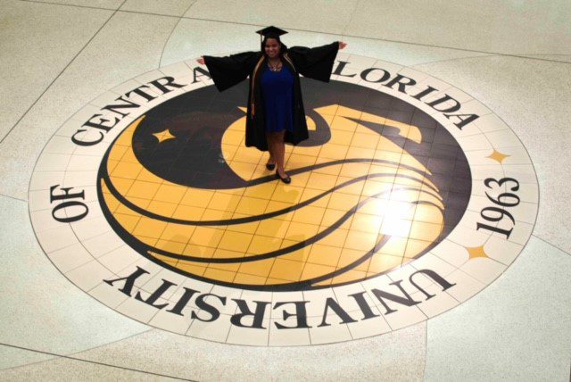 Alexis Weber standing on the UCF seal 