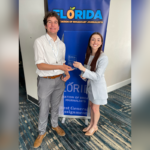 Two people stand in front of a 