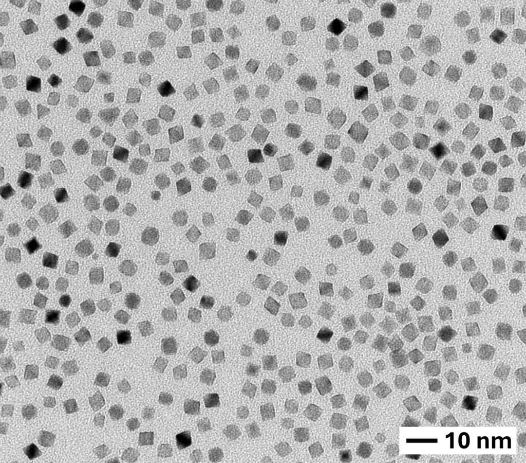 Transmission electron microscope image showing a dense distribution of uniformly sized, square-shaped nanoparticles. A scale bar indicates 10 nanometers for reference.