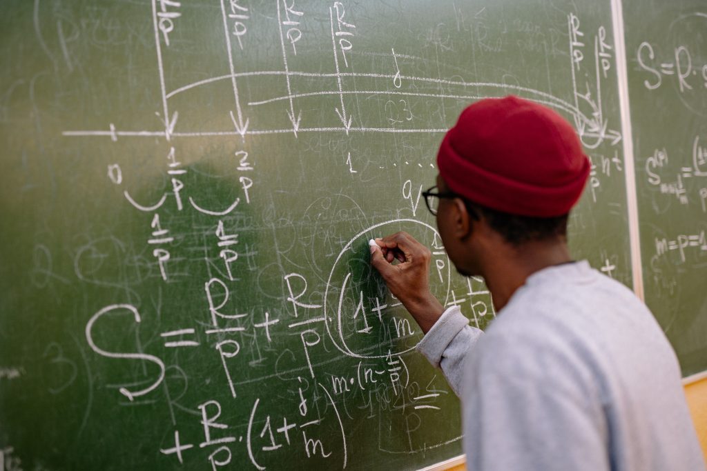 Student working out a mathematical problem at the blackboard
