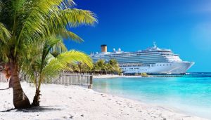 white sand beach with cruise ship in the background