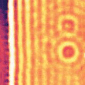 Heat map image showing vertical stripes and concentric circles in yellow, orange, and red tones, with intensity varying across the image.