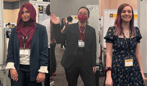 Three individuals stand in front of research posters at an academic event, each wearing a name badge and dressed in semi-formal or business attire.
