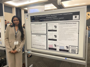 A woman in business attire stands next to a research poster on gender categorization at an academic conference.