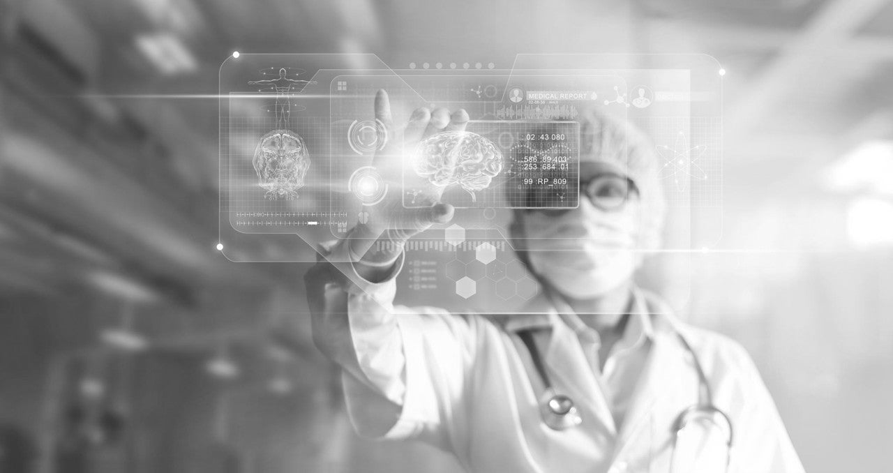 A doctor in a lab coat and mask interacts with a transparent digital screen displaying brain images and medical data.