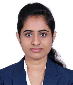 A woman with dark hair tied back, wearing a navy blazer and white shirt, poses for a formal portrait against a plain white background.