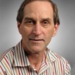 A man in a striped shirt is posing for a photo.